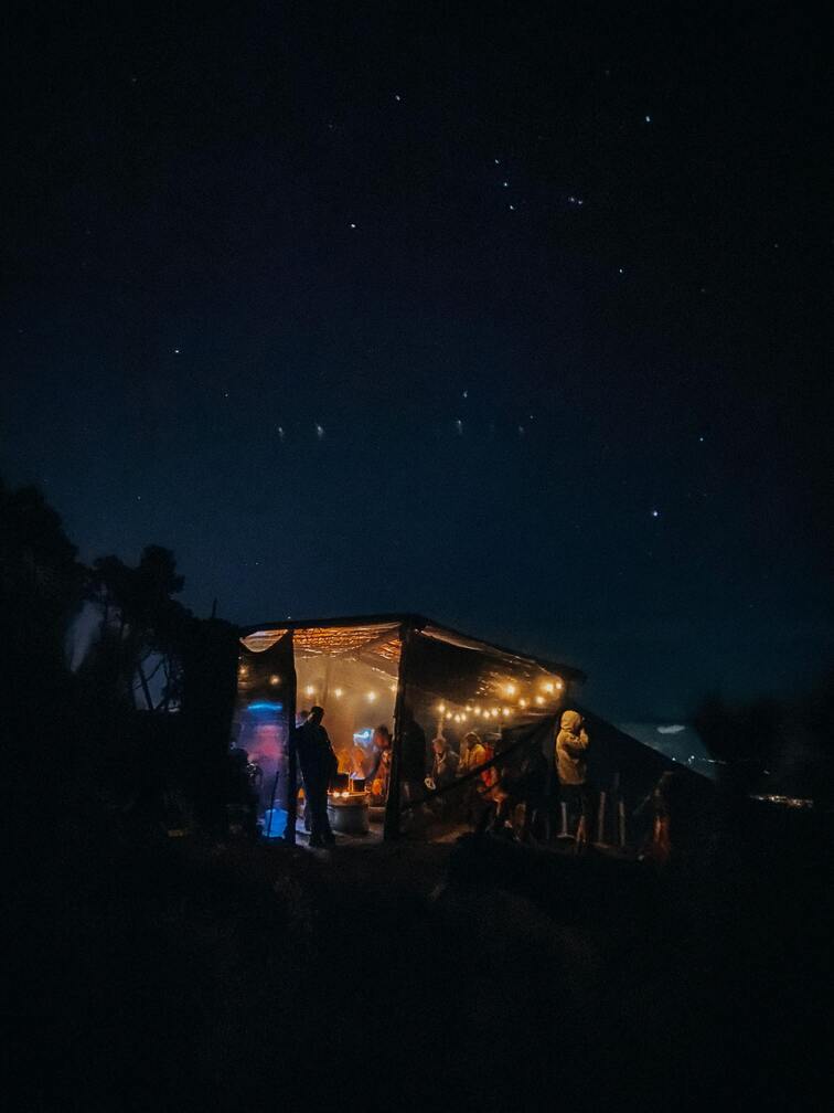 A camp on top of a mountain during the night.