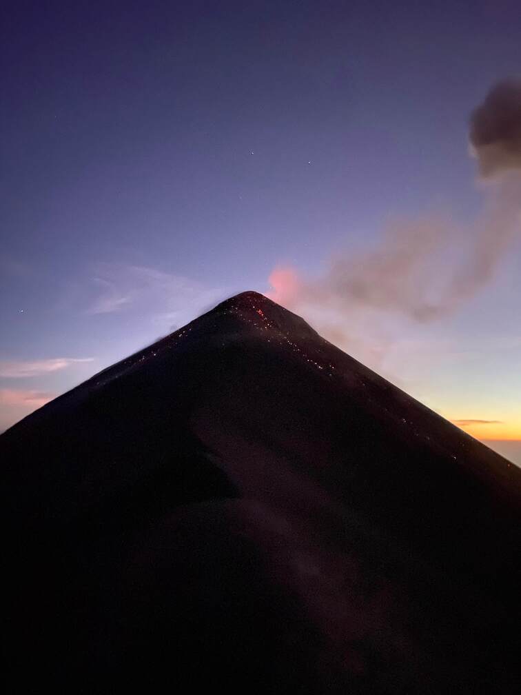 A volcano, some lava and a purple sky.