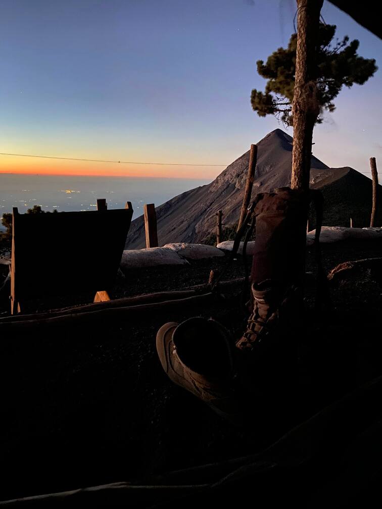 Camp on top of a mountain with views to a volcano.