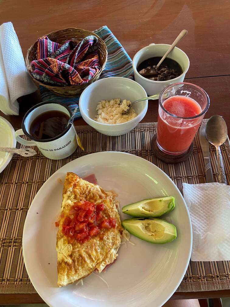 Typical breakfast with an omelette, avocado, beans, juice and coffee. 